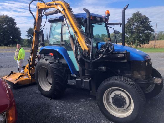 New Holland TS100 4x4 cab tractor with boom mower